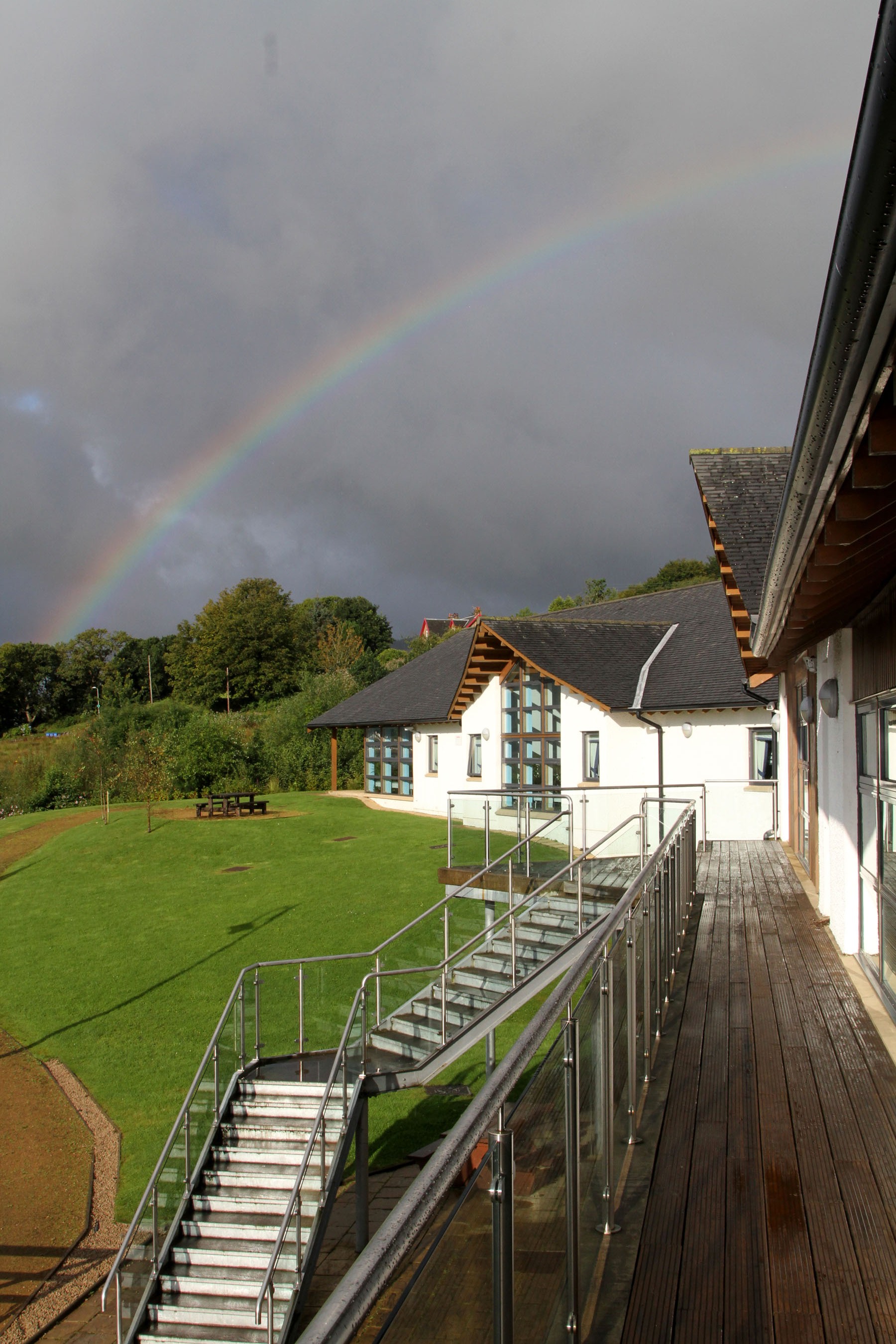 Exterior of the centre with a rainbow in the background.
