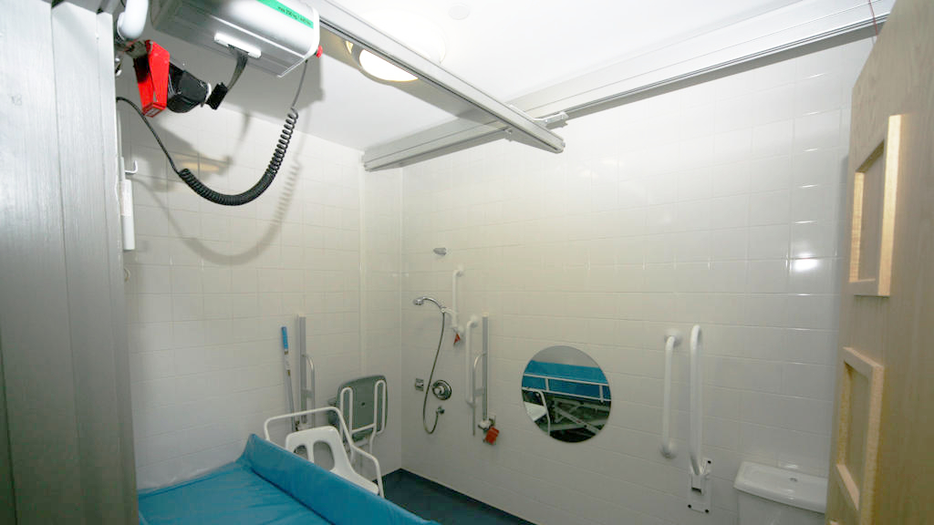 Room with bed, toilet and hoists.