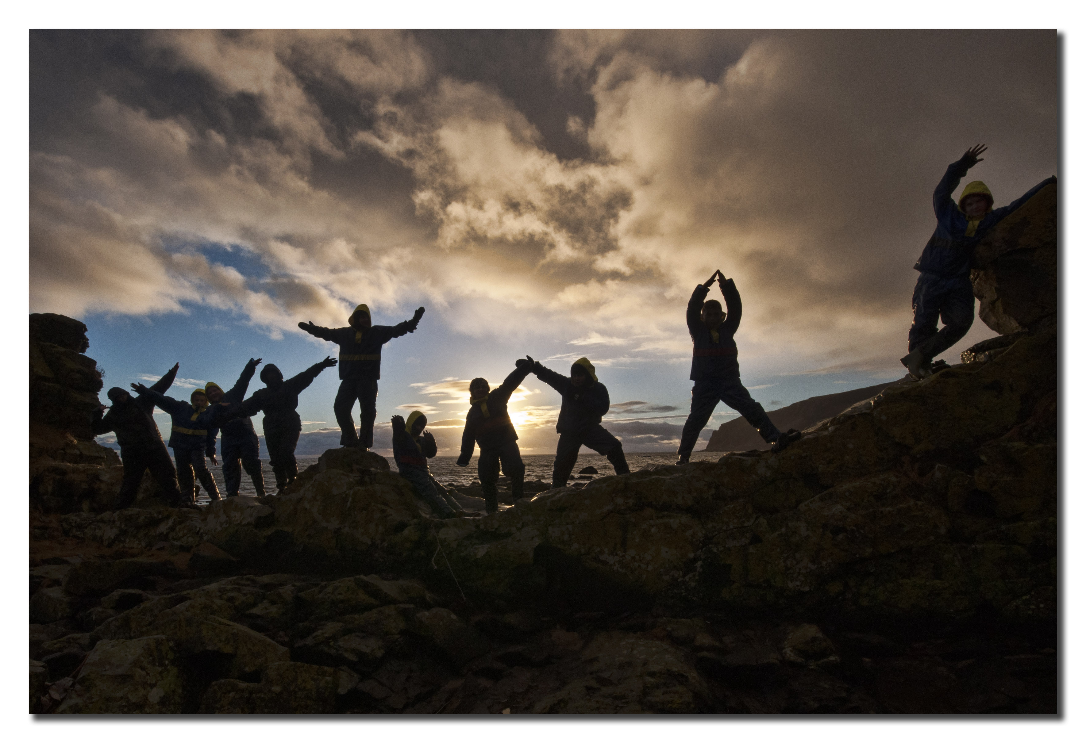 People in silhouette against a sunset.
