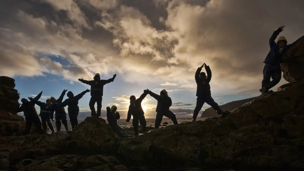 People in silhouette against a sunset.