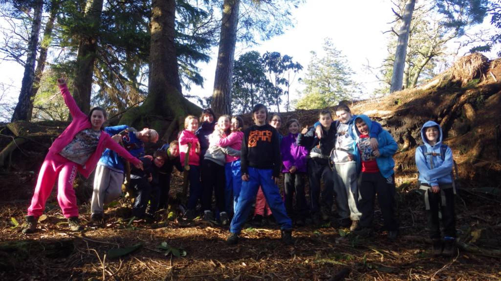 Group of kids with forest in the background.